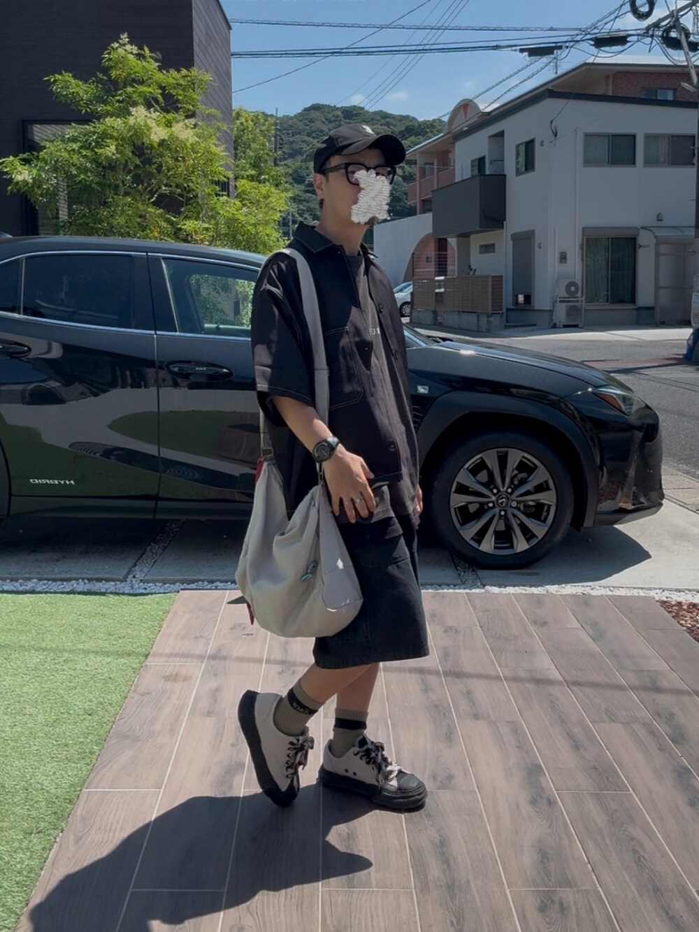 ベージュ系のスニーカー、ブラック系のデニムパンツ、グレー系のTシャツ/カットソーを着用したメンズの夏コーディネートの2枚目の写真