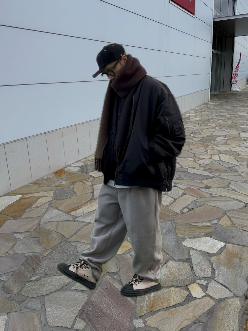 ベージュ系のスラックス、ベージュ系のスニーカー、ブラック系のスウェットを着用したメンズの冬コーディネートの2枚目の写真