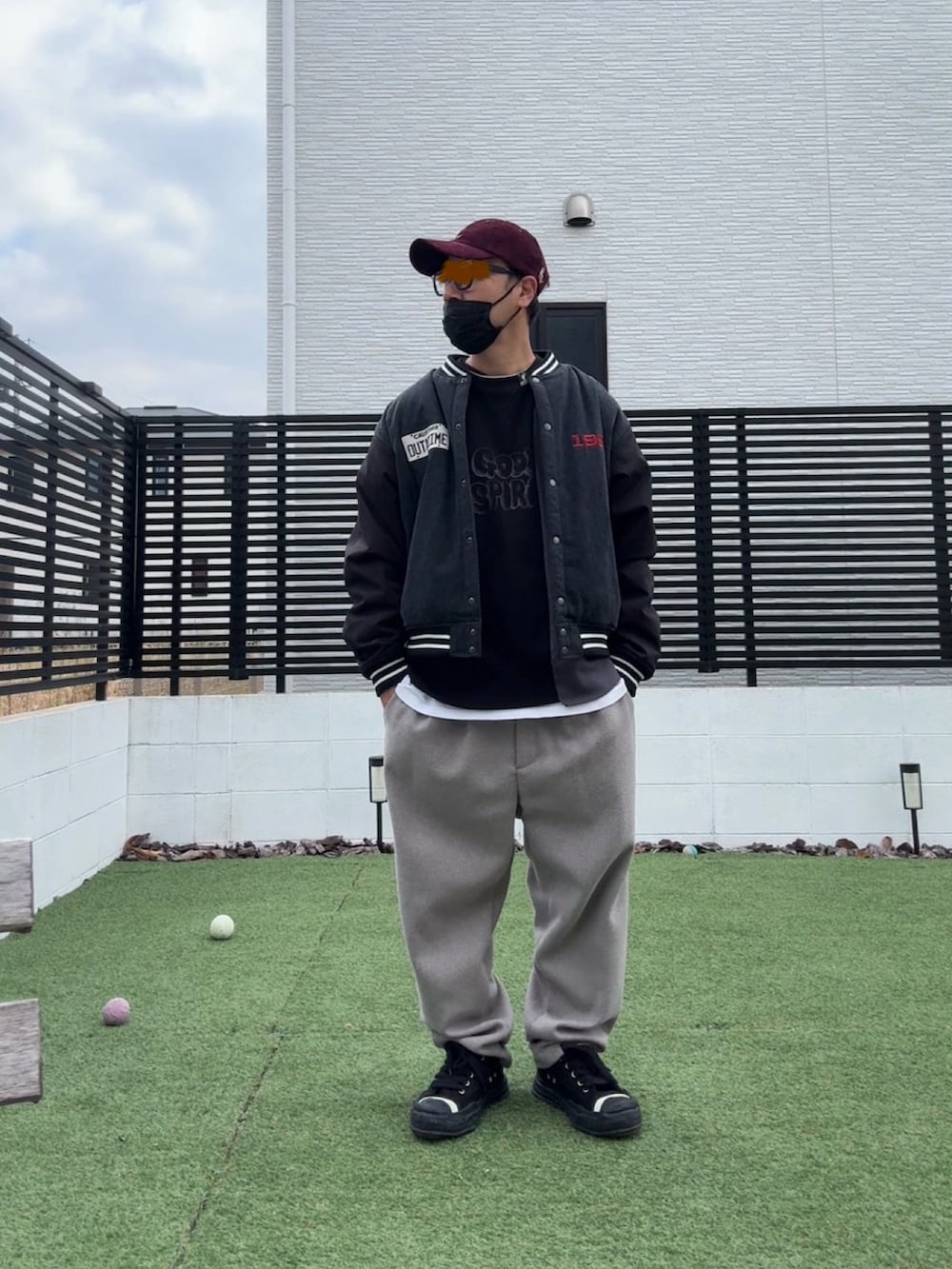 ブラック系のスタジャン、ベージュ系のスラックス、ブラック系のスニーカーを着用したメンズの冬コーディネートの2枚目の写真