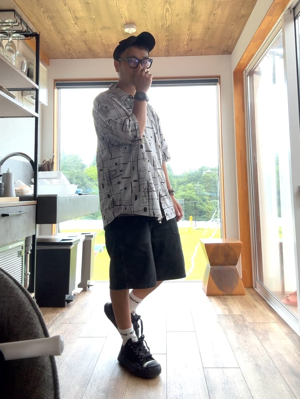 ブラック系のデニムパンツ、ブラック系のスニーカー、グレー系のシャツ/ブラウスを着用したメンズの夏コーディネートの3枚目の写真