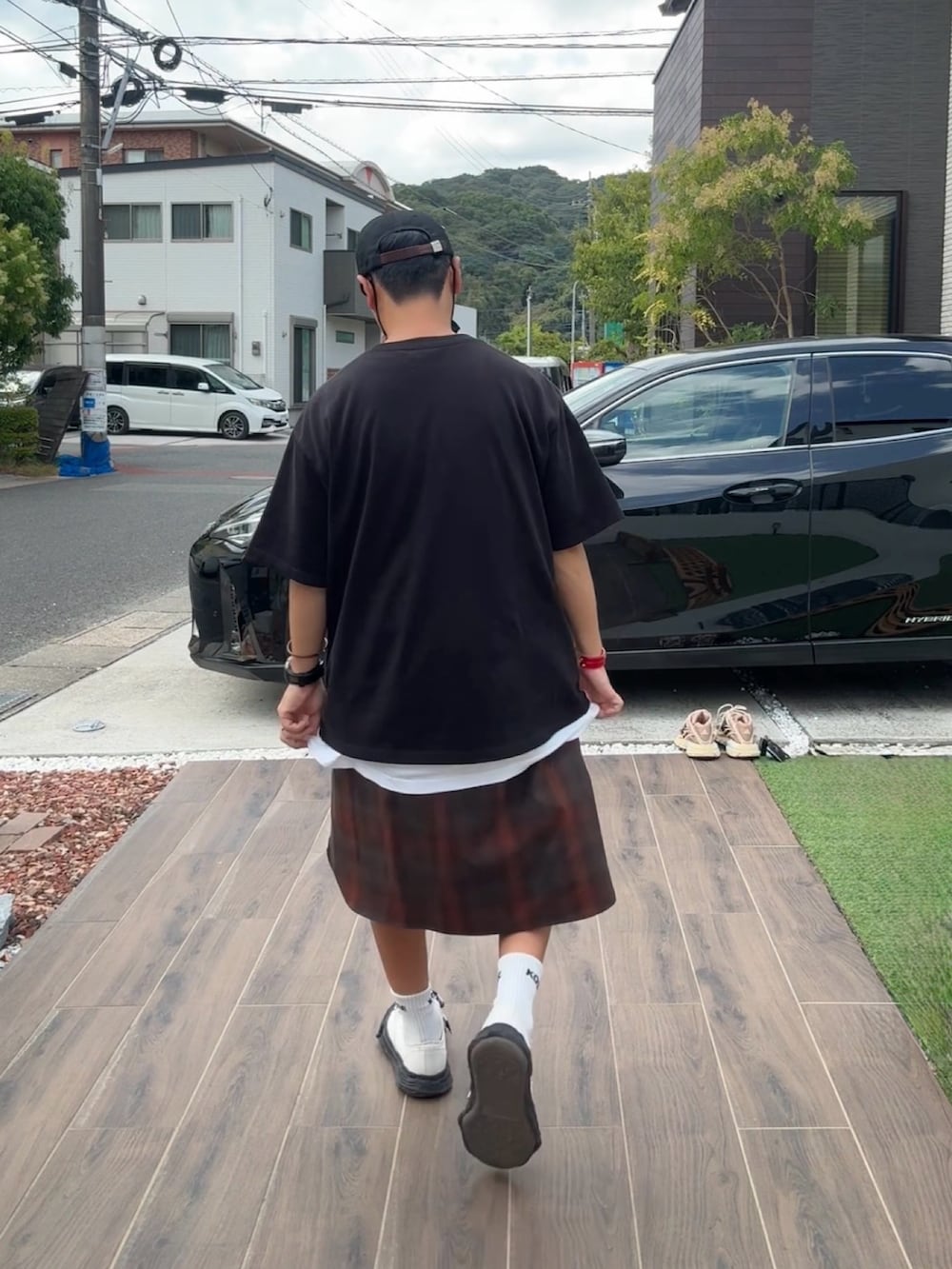 ブラック系のTシャツ/カットソー、ブラック系のデニムパンツ、ブラック系のスニーカーを着用したメンズの夏コーディネートの2枚目の写真