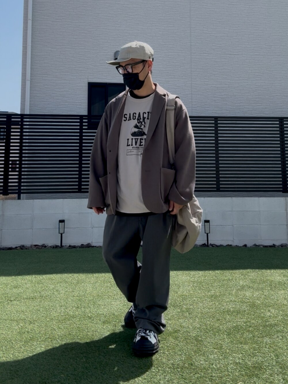 ベージュ系のテーラードジャケット、グレー系のTシャツ/カットソー、グリーン系のスウェットパンツを着用したメンズの春コーディネートの2枚目の写真