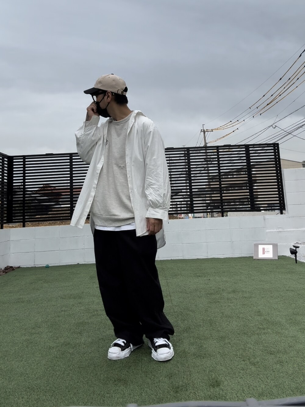 ホワイト系のスウェット、ブラック系のチノパンツ、ブラック系のスニーカーを着用したメンズの春コーディネートの2枚目の写真