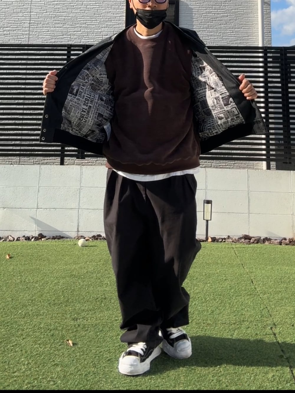 ブラウン系のスウェット、ブラック系のスタジャン、ブラック系のチノパンツを着用したメンズの冬コーディネートの3枚目の写真