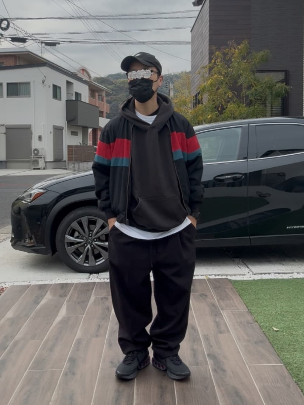 グレー系のスニーカー、ブラック系のチノパンツ、ブラック系のパーカーを着用したメンズの春コーディネートの2枚目の写真