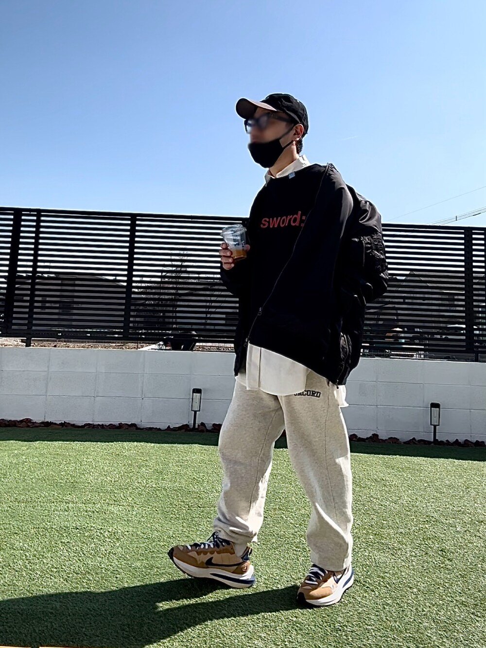 ブラック系のスウェット、ブラック系のMA-1、ベージュ系のスウェットパンツを着用したメンズの冬コーディネートの2枚目の写真