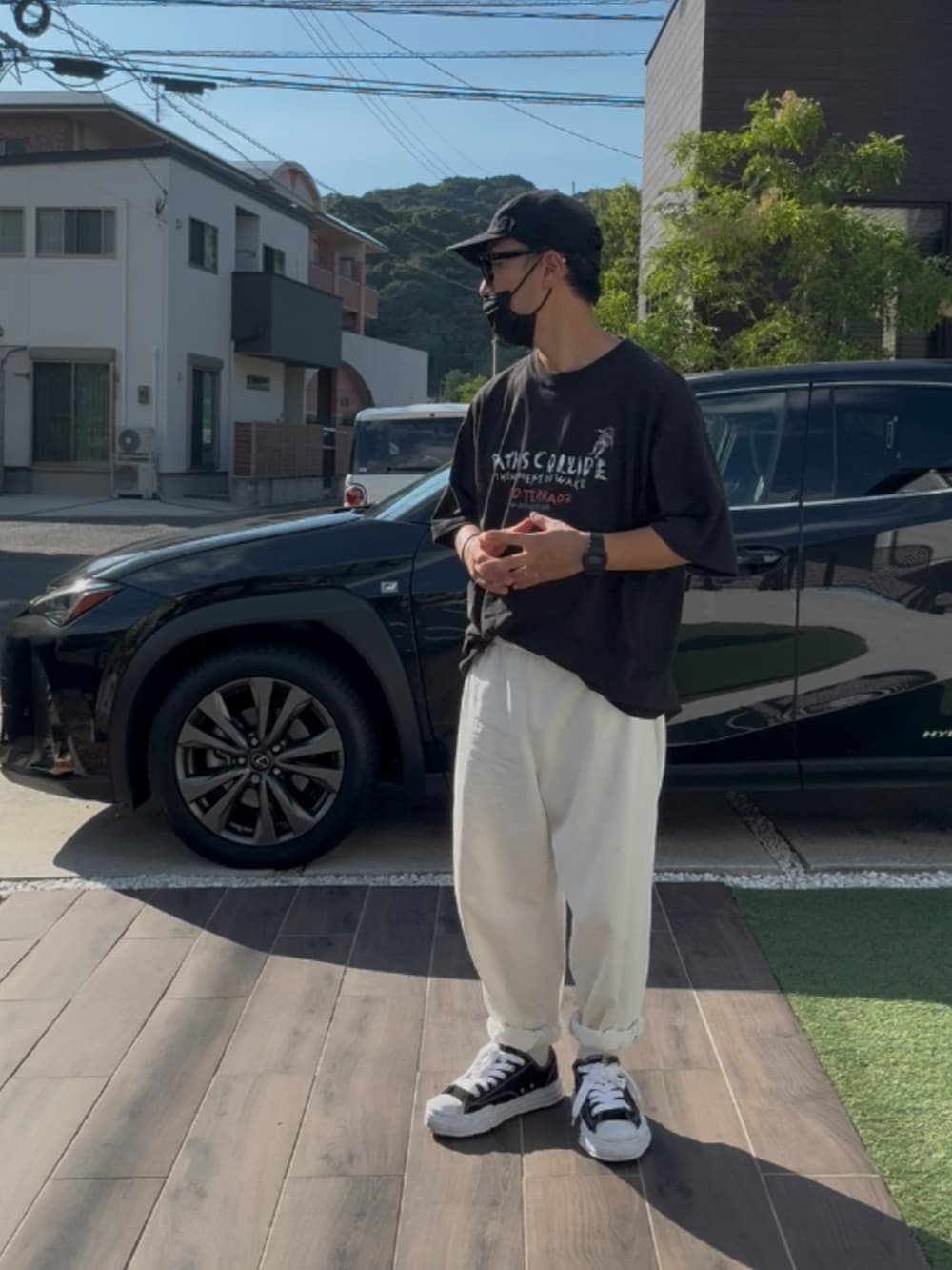 ブラック系のTシャツ/カットソー、ブラック系のスニーカー、ホワイト系のデニムパンツを着用したメンズの秋コーディネートの2枚目の写真