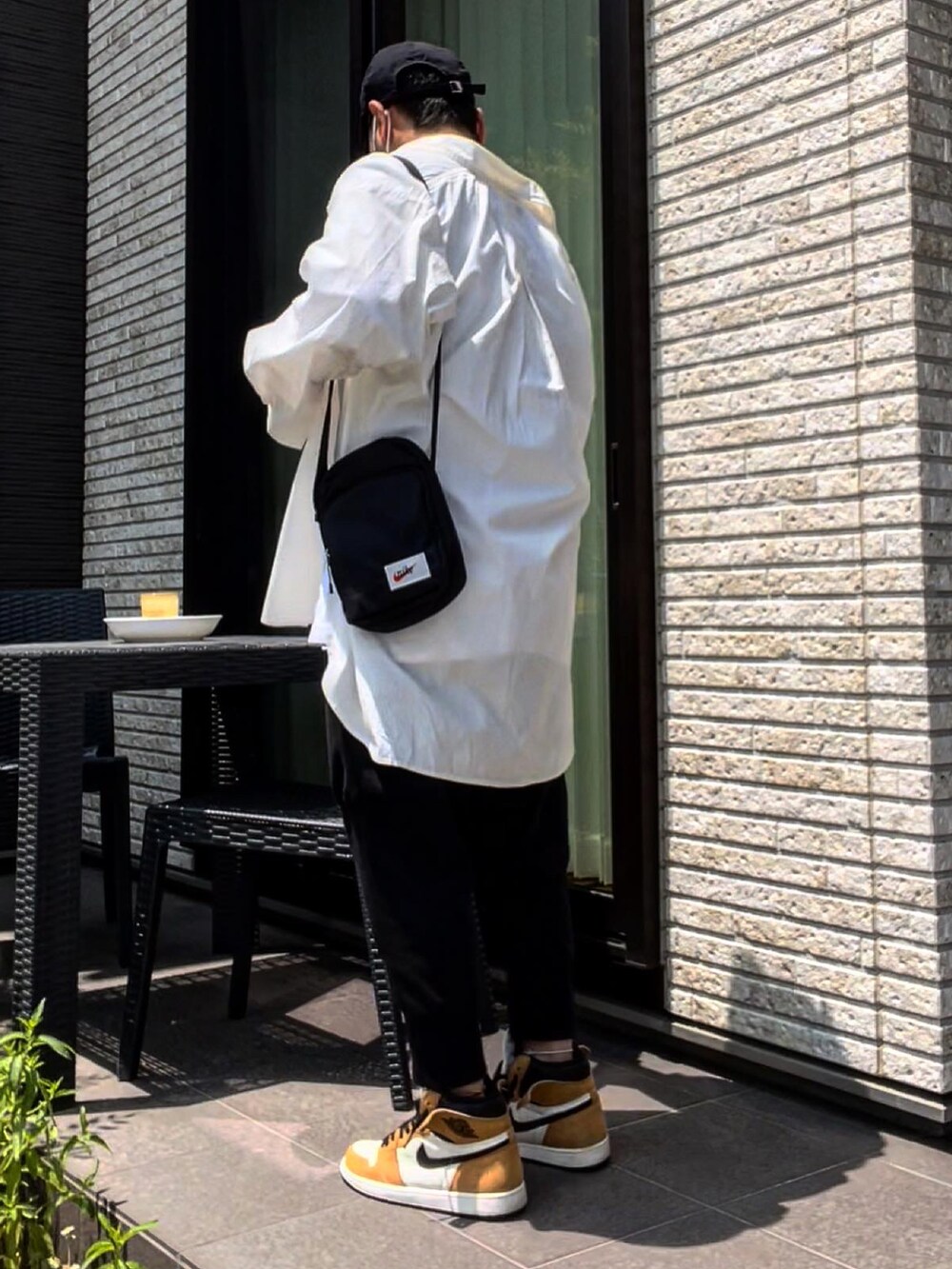ブラック系のスウェットパンツ、ベージュ系のスニーカー、ホワイト系のTシャツ/カットソーを着用したメンズの夏コーディネートの2枚目の写真