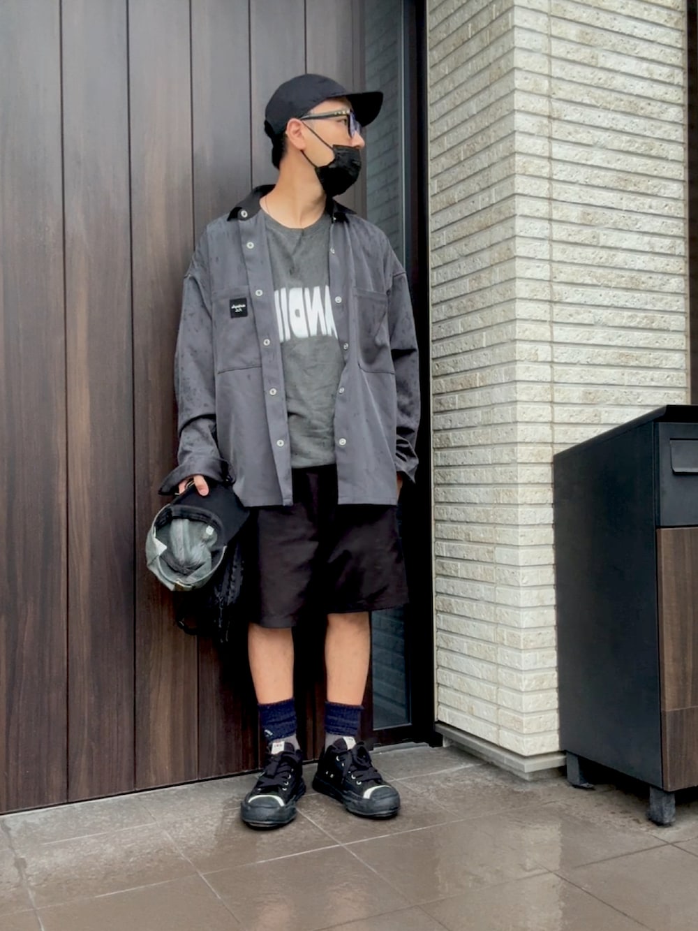 ホワイト系のTシャツ/カットソー、ブラック系のスニーカー、グレー系のナイロンジャケットを着用したメンズの秋コーディネートの2枚目の写真