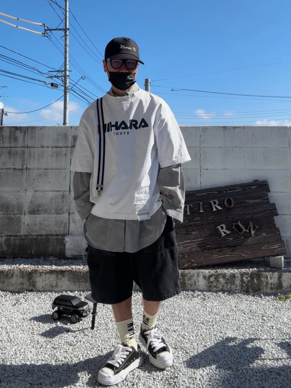 ブラック系のデニムパンツ、ホワイト系のTシャツ/カットソー、グレー系のスニーカーを着用したメンズの春コーディネートの3枚目の写真