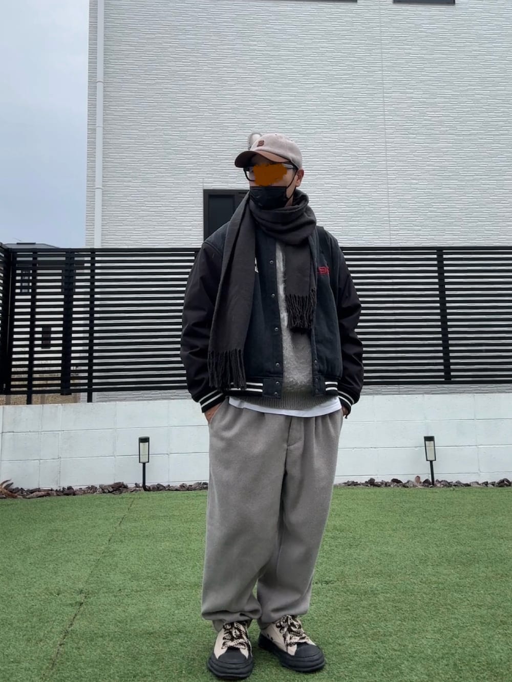 グレー系のニット/セーター、ベージュ系のスラックス、ブラック系のスタジャンを着用したメンズの冬コーディネートの2枚目の写真