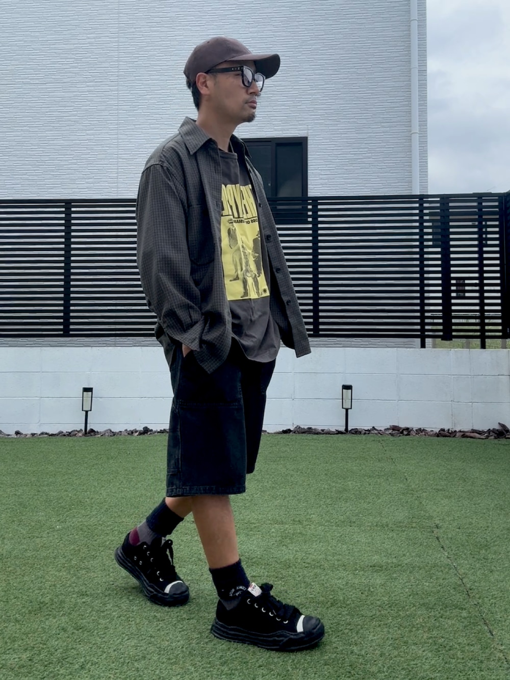 ブラック系のデニムパンツ、ブラック系のスニーカー、グリーン系のシャツ/ブラウスを着用したメンズの秋コーディネートの2枚目の写真