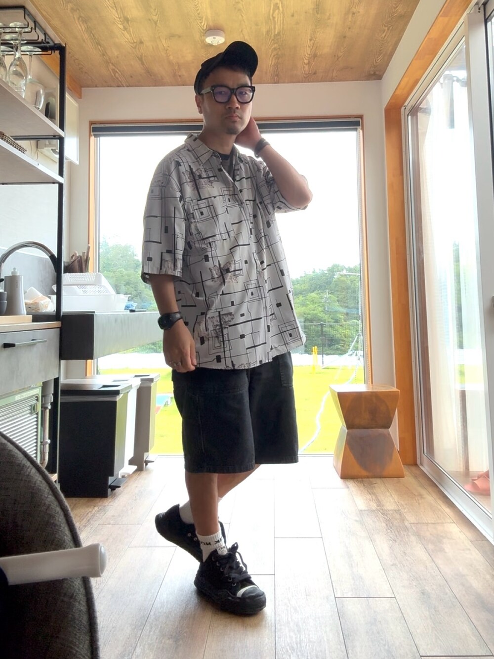 ブラック系のデニムパンツ、ブラック系のスニーカー、グレー系のシャツ/ブラウスを着用したメンズの夏コーディネートの2枚目の写真