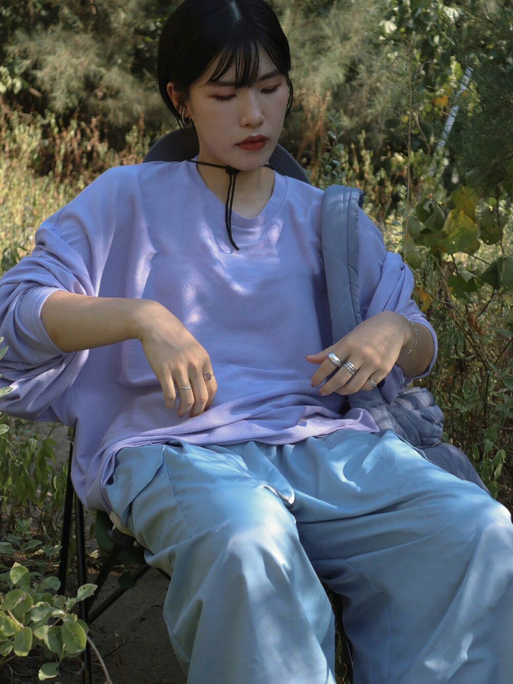 パープル系のトップス、ブルー系のパンツ、イエロー系のサンダルを着用したレディースの夏コーディネートの3枚目の写真