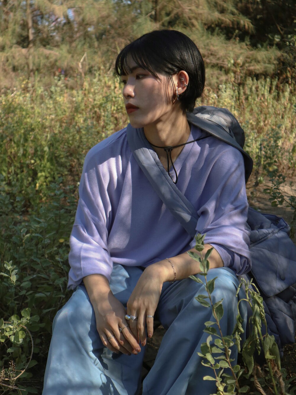 パープル系のトップス、ブルー系のパンツ、イエロー系のサンダルを着用したレディースの夏コーディネートの4枚目の写真