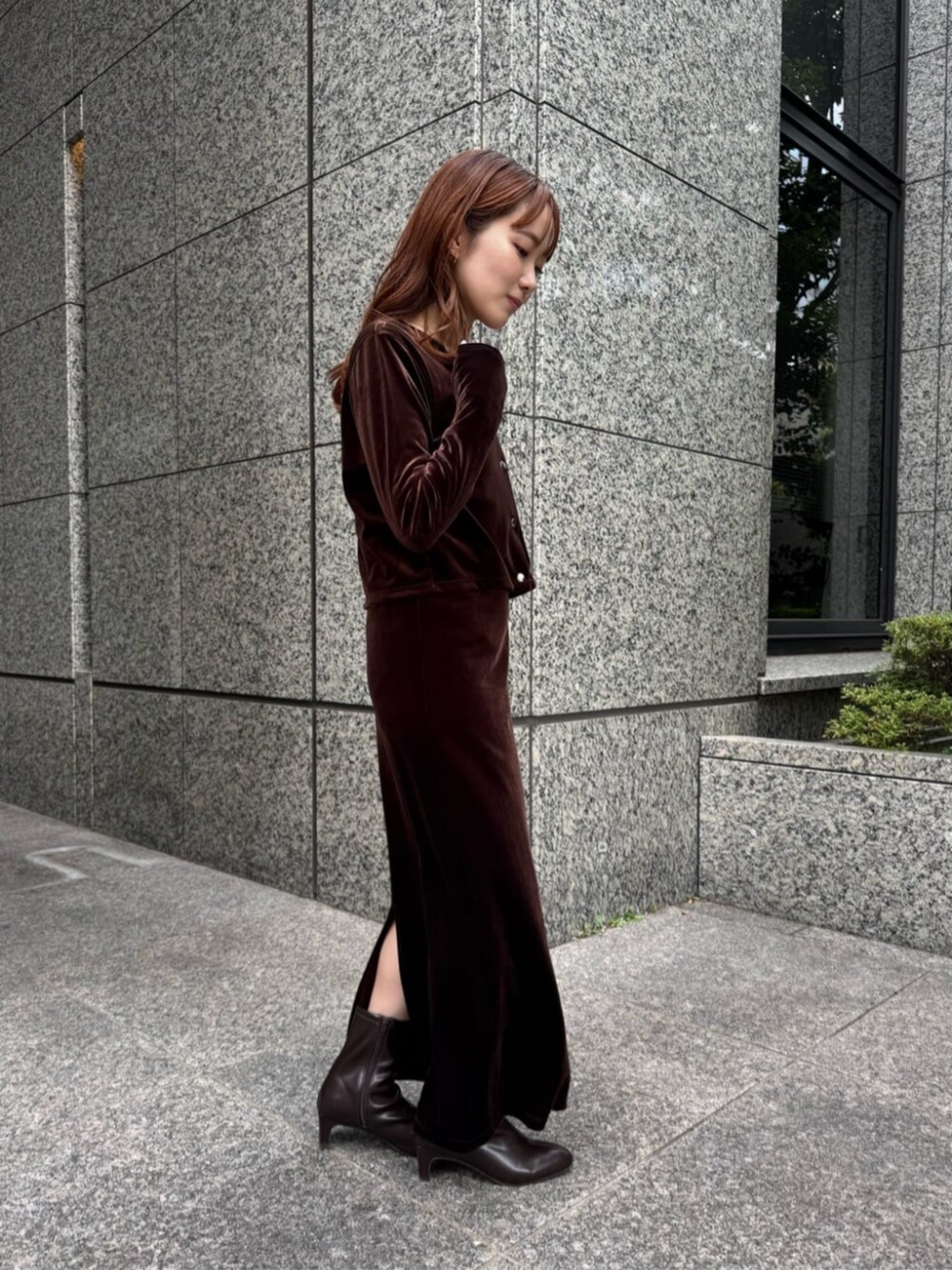 ブラウン系のワンピース、ブラウン系のブーツ、ホワイト系のTシャツ/カットソーを着用したレディースの秋コーディネートの2枚目の写真