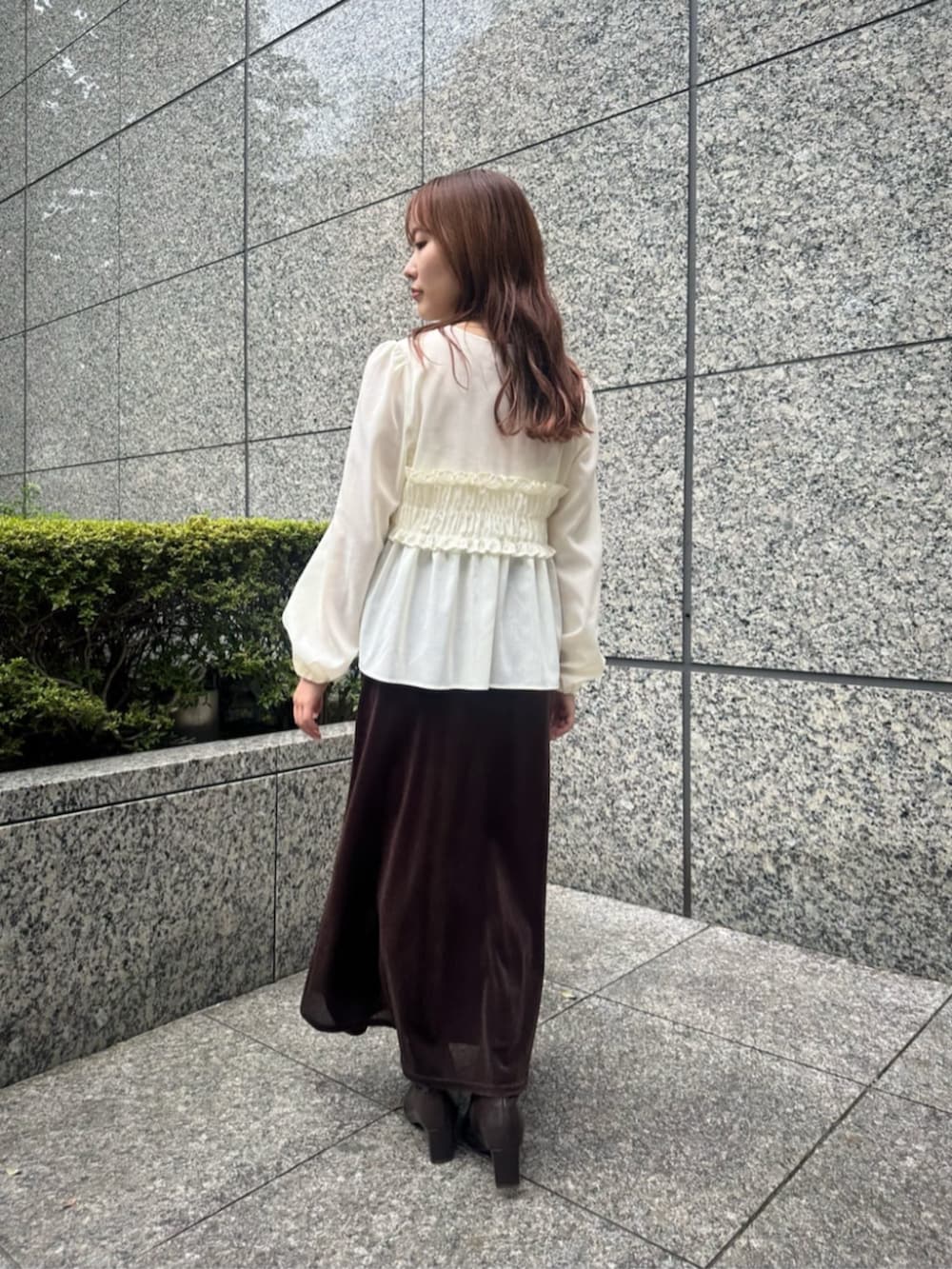 ホワイト系のシャツ/ブラウス、ブラウン系のスカート、ブラウン系のブーツを着用したレディースの秋コーディネートの3枚目の写真