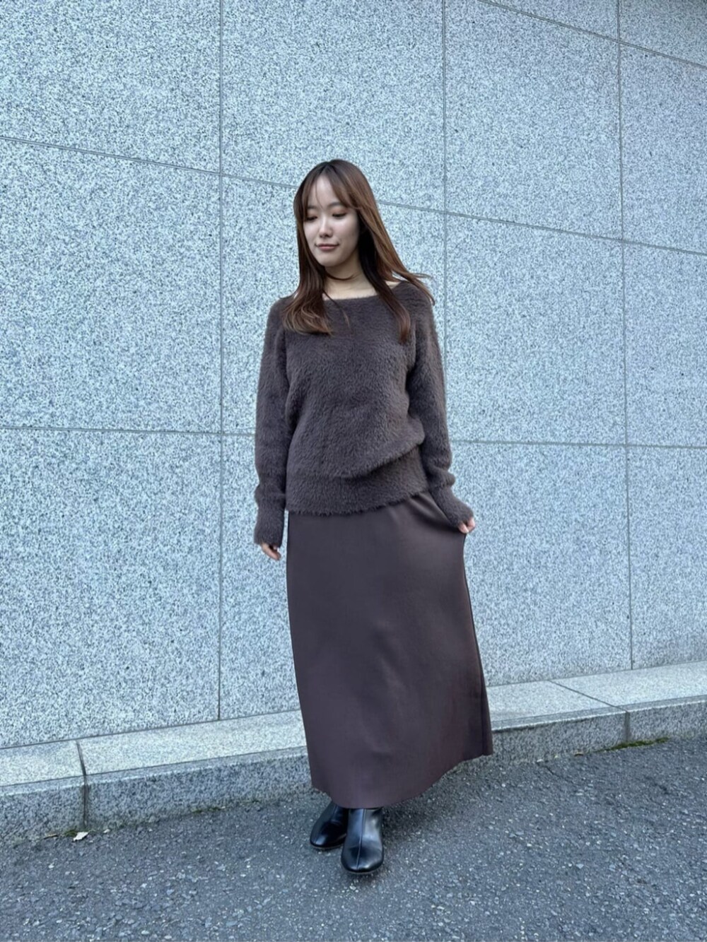 ブラック系のブーツ、ベージュ系のその他パンツ、ブラウン系のワンピースを着用したレディースの冬コーディネートの3枚目の写真