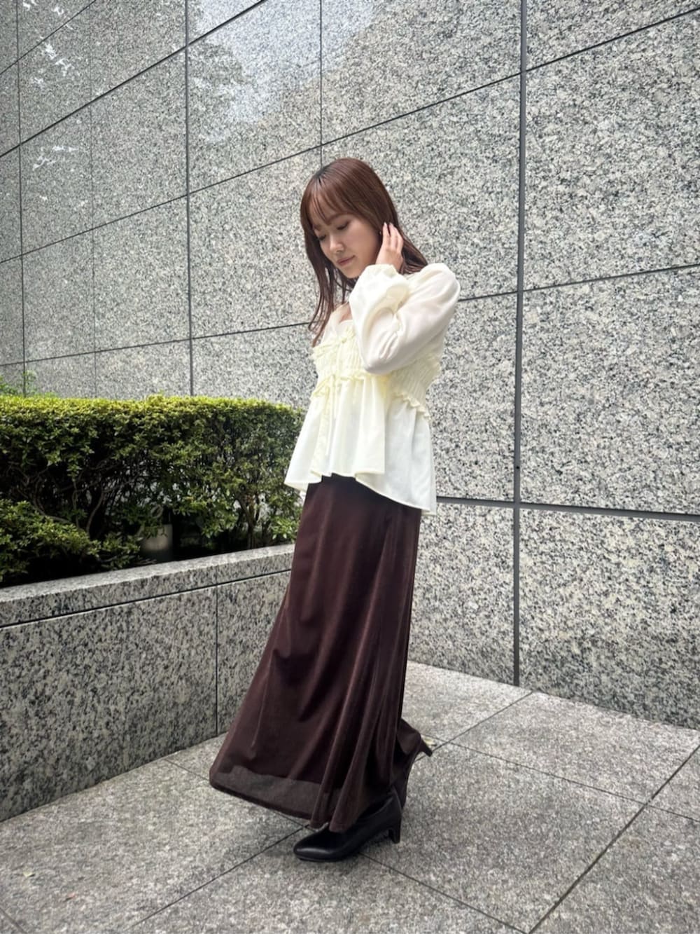 ホワイト系のシャツ/ブラウス、ブラウン系のスカート、ブラウン系のブーツを着用したレディースの秋コーディネートの2枚目の写真