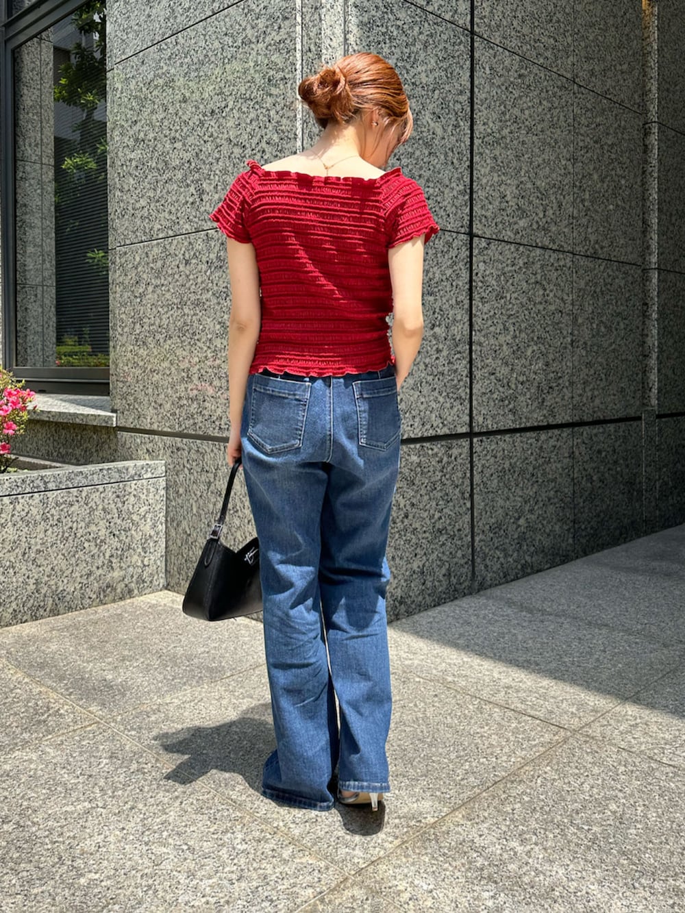 レッド系のTシャツ/カットソー、ブルー系のデニムパンツ、ブラック系のショルダーバッグを着用したレディースの夏コーディネートの2枚目の写真