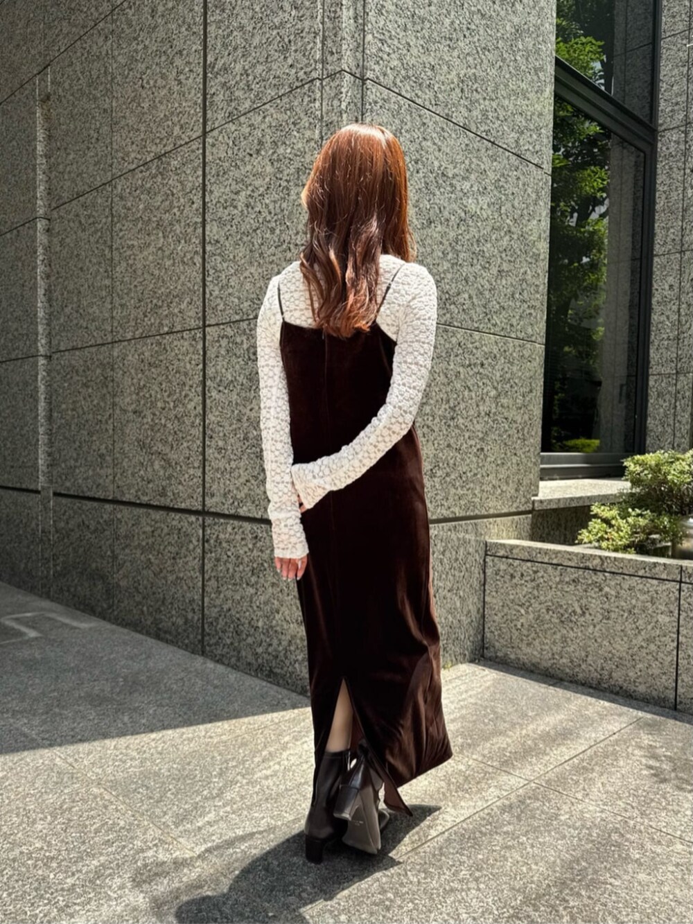 ブラウン系のワンピース、ブラウン系のブーツ、ホワイト系のTシャツ/カットソーを着用したレディースの秋コーディネートの5枚目の写真