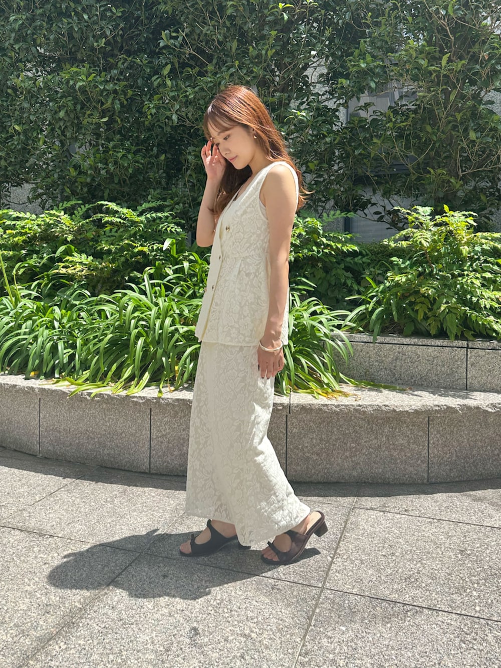 ブラック系のサンダル、ホワイト系のその他アウター、ホワイト系のスカートを着用したレディースの夏コーディネートの3枚目の写真