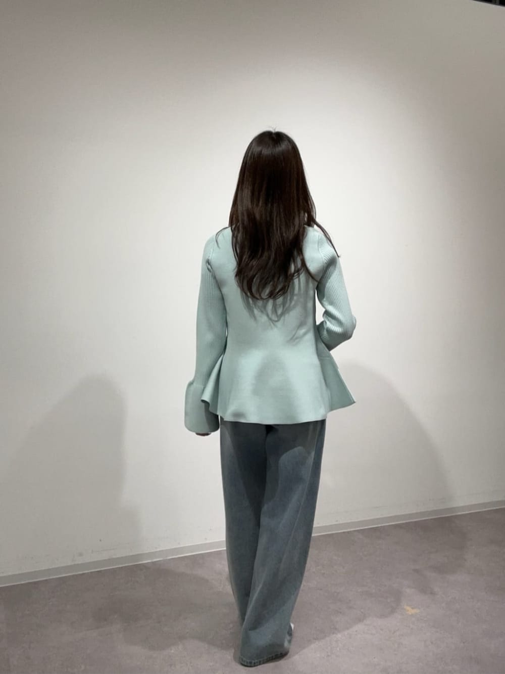 グリーン系のニット/セーター、ブルー系のデニムパンツを着用したレディースの冬コーディネートの3枚目の写真