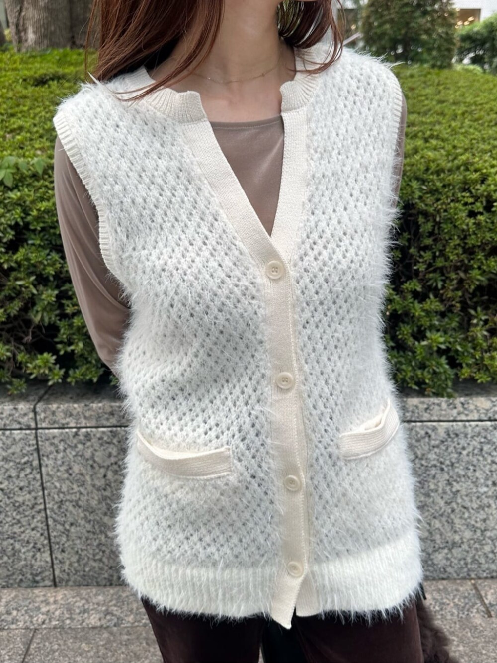 ブラック系のブーツ、ホワイト系のベスト、ベージュ系のTシャツ/カットソーを着用したレディースの秋コーディネートの4枚目の写真