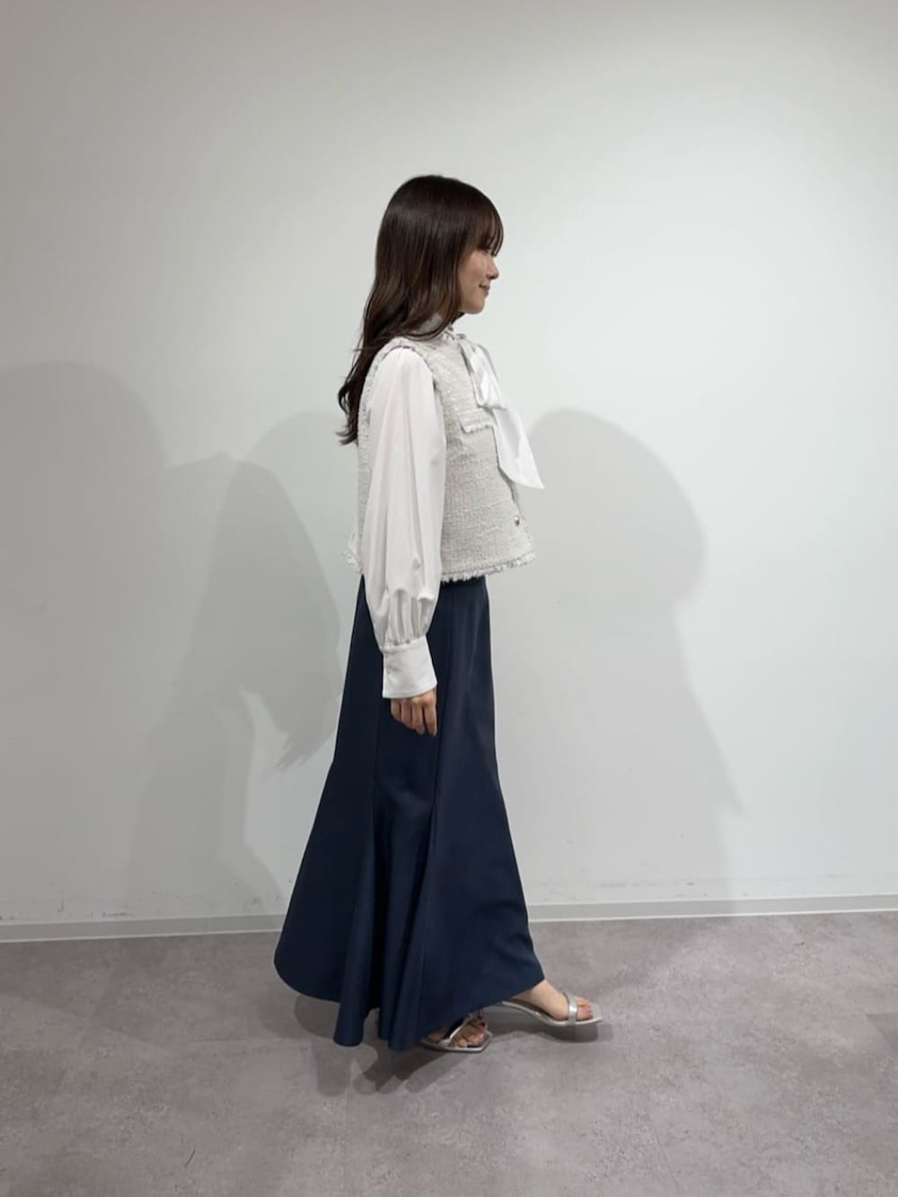 ブルー系のスカート、ホワイト系のシャツ/ブラウス、ホワイト系のその他アウターを着用したレディースの冬コーディネートの2枚目の写真