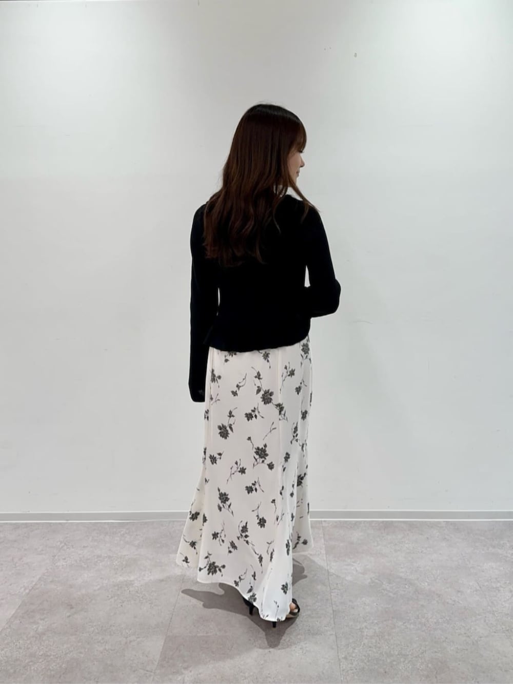 ブラック系のカーディガン/ボレロ、ホワイト系のスカートを着用したレディースの春コーディネートの3枚目の写真