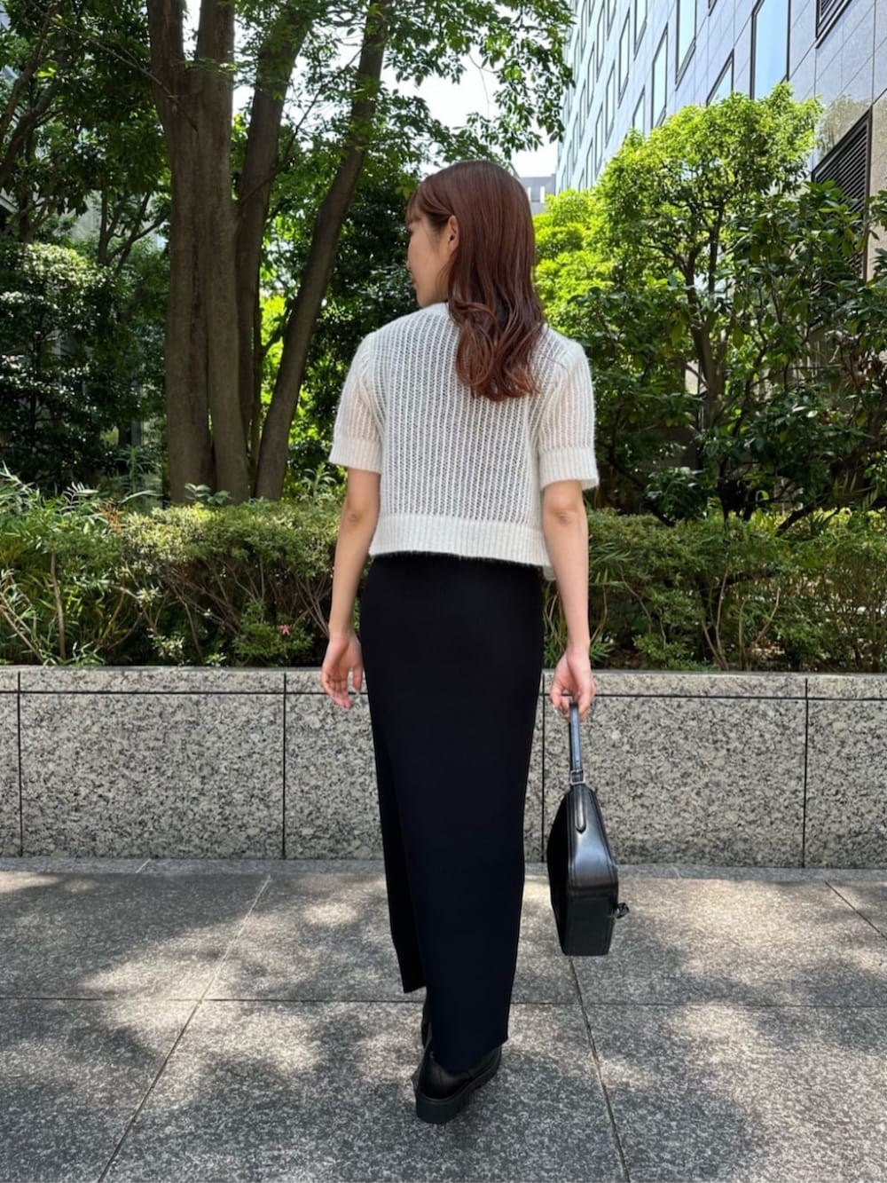 ブラック系のショルダーバッグ、ブラック系のワンピース、ブラック系のブーツを着用したレディースの秋コーディネートの3枚目の写真