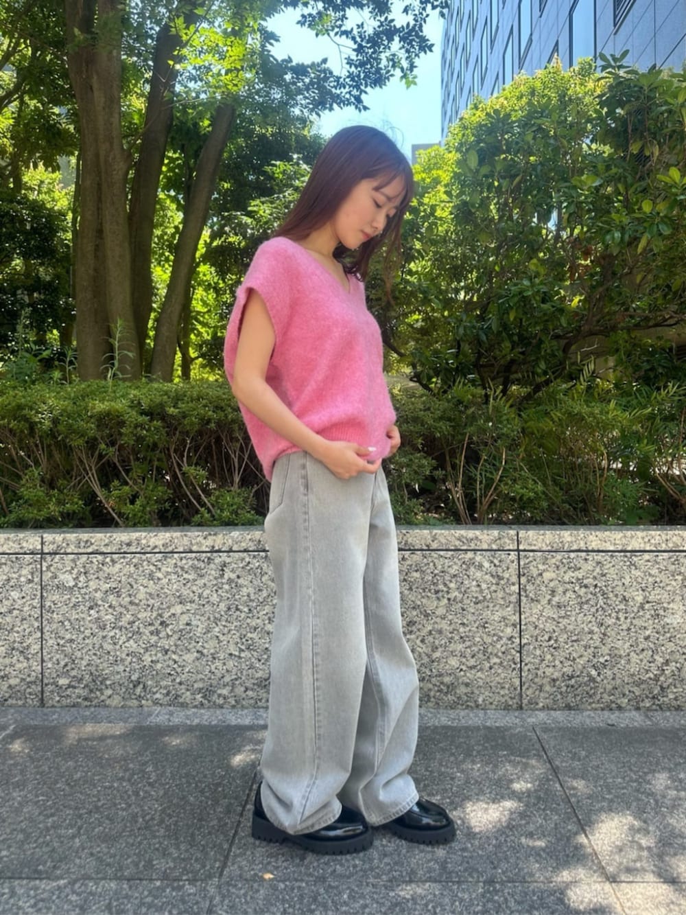 レッド系のベスト、グレー系のデニムパンツ、ブラック系のローファーを着用したレディースの秋コーディネートの2枚目の写真