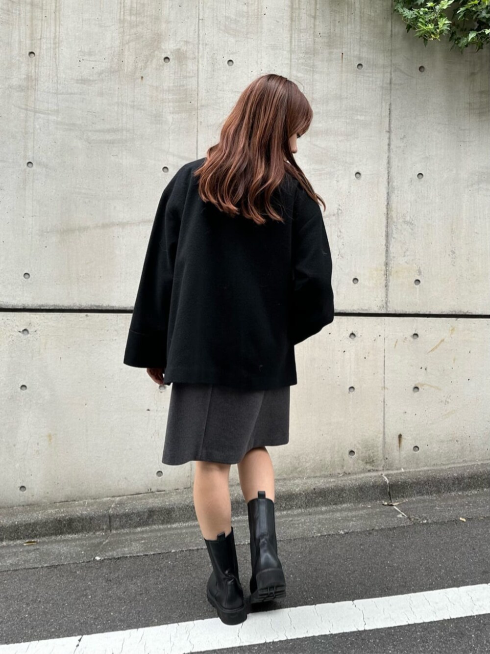 ブラック系のブーツ、グレー系のニット/セーター、グレー系のジャンパースカートを着用したレディースの秋コーディネートの3枚目の写真