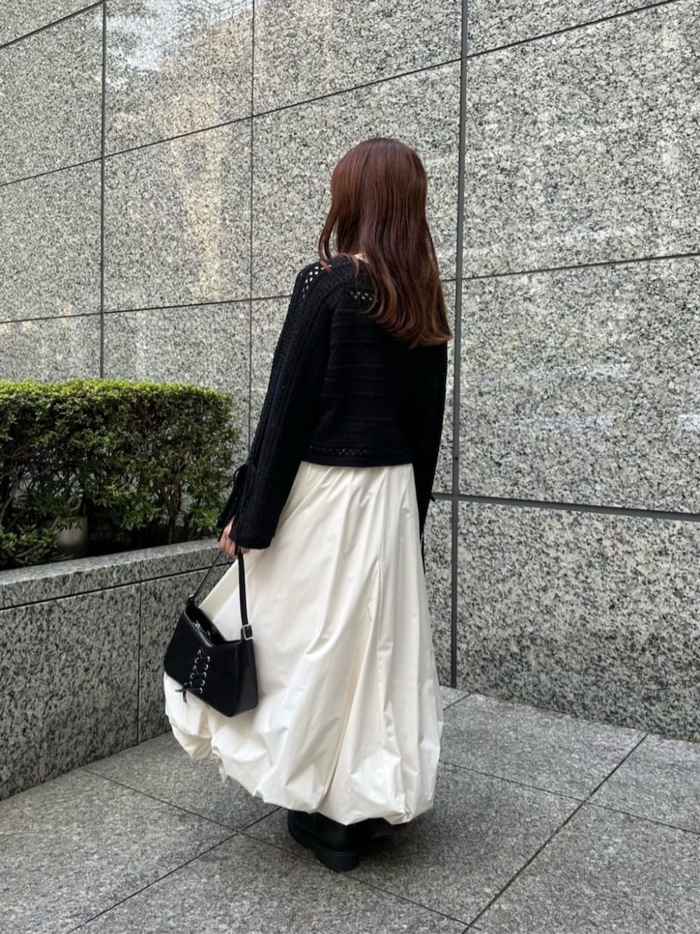 ブラック系のショルダーバッグ、ブラック系のブーツ、ホワイト系のスカートを着用したレディースの秋コーディネートの3枚目の写真