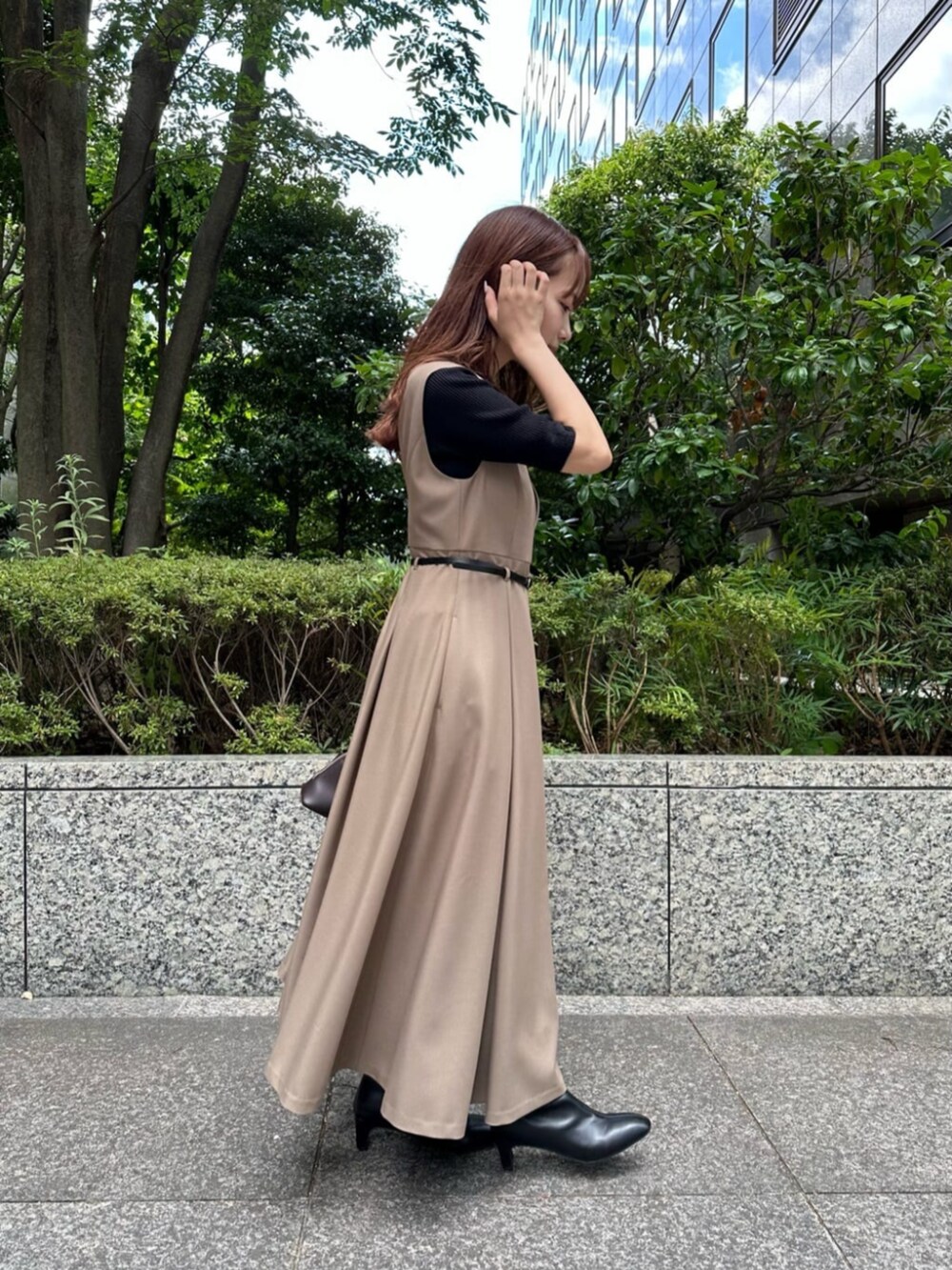 ブラック系のブーツ、ブラック系のニット/セーター、ベージュ系のジャンパースカートを着用したレディースの秋コーディネートの2枚目の写真