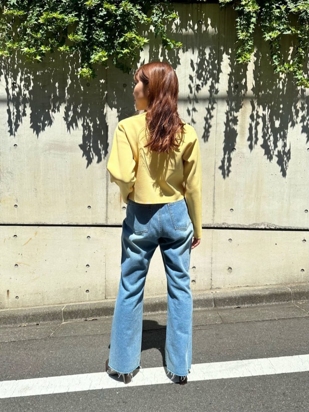 ブラウン系のブーツ、イエロー系のカーディガン/ボレロ、ブルー系のデニムパンツを着用したレディースの秋コーディネートの3枚目の写真