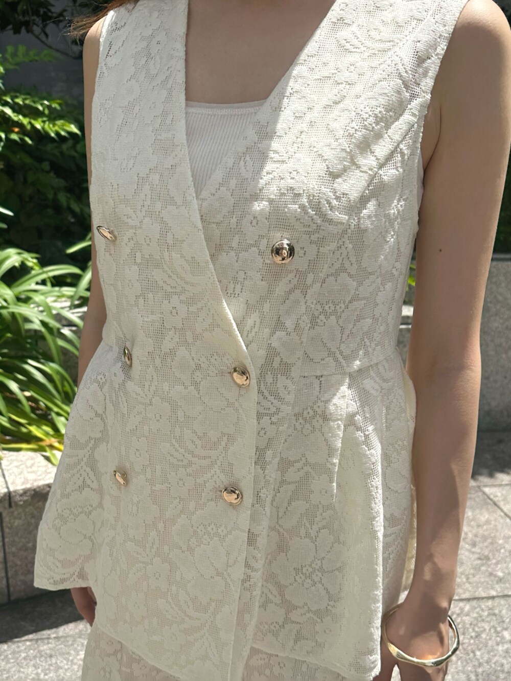 ブラック系のサンダル、ホワイト系のその他アウター、ホワイト系のスカートを着用したレディースの夏コーディネートの4枚目の写真