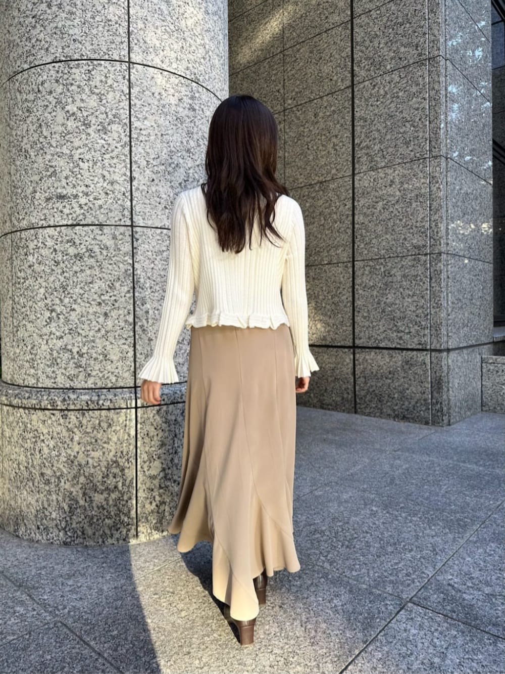 ブラウン系のブーツ、ブラウン系のチェスターコート、ホワイト系のニット/セーターを着用したレディースの冬コーディネートの5枚目の写真