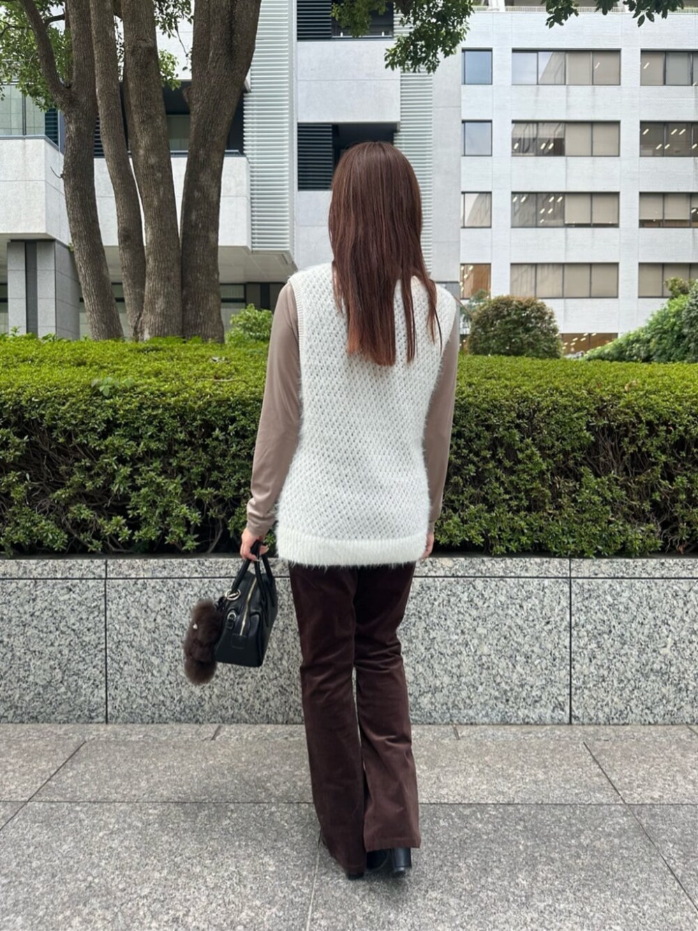 ブラック系のブーツ、ホワイト系のベスト、ベージュ系のTシャツ/カットソーを着用したレディースの秋コーディネートの3枚目の写真