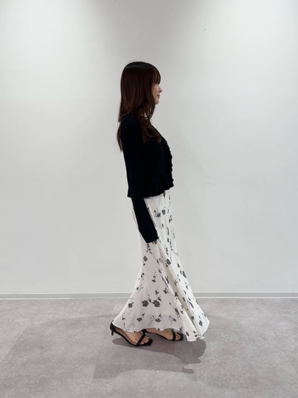 ブラック系のカーディガン/ボレロ、ホワイト系のスカートを着用したレディースの春コーディネートの2枚目の写真