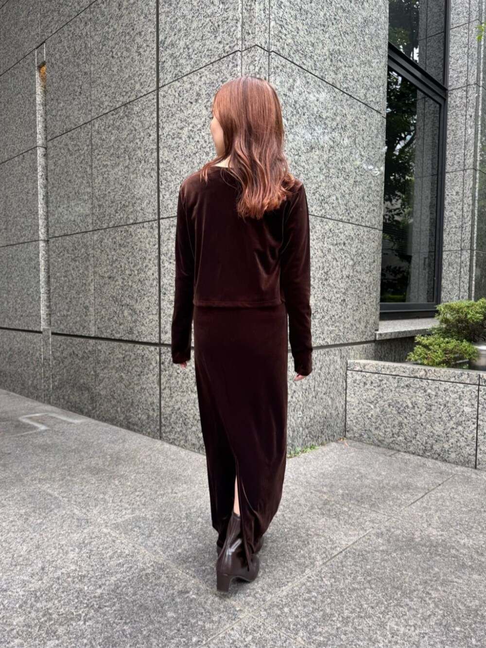 ブラウン系のワンピース、ブラウン系のブーツ、ホワイト系のTシャツ/カットソーを着用したレディースの秋コーディネートの3枚目の写真