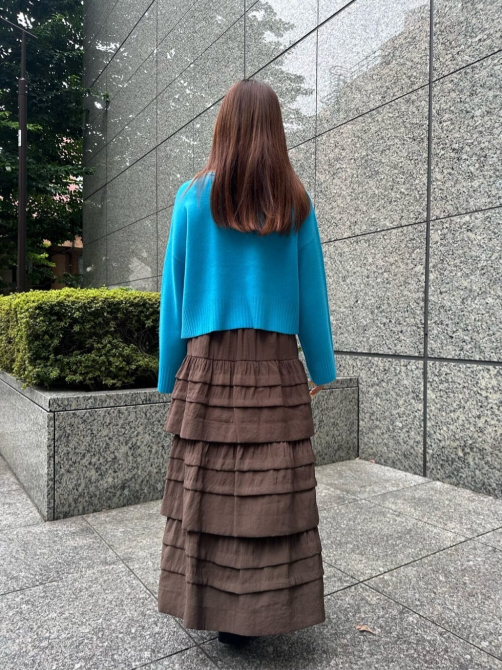 ブラック系のブーツ、ブルー系のニット/セーター、ブラウン系のスカートを着用したレディースの秋コーディネートの3枚目の写真