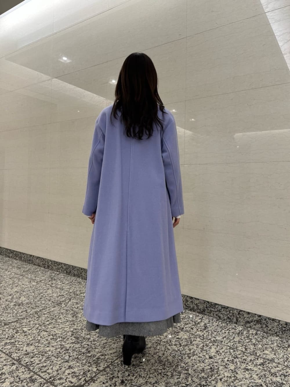 ブラック系のブーツ、ブルー系のノーカラーコート、ホワイト系のニット/セーターを着用したレディースの冬コーディネートの3枚目の写真