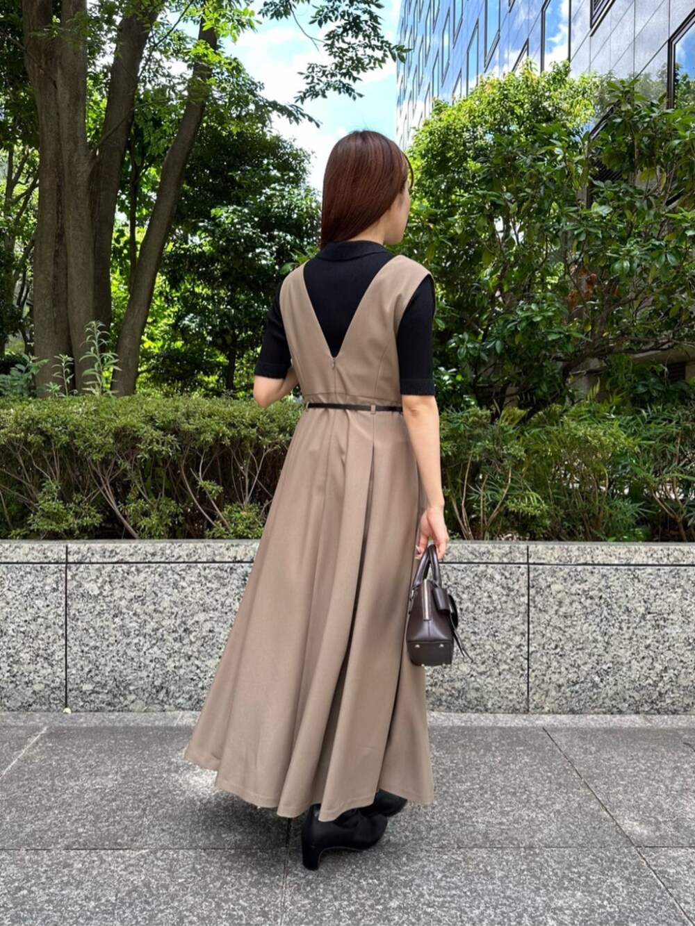 ブラック系のブーツ、ブラック系のニット/セーター、ベージュ系のジャンパースカートを着用したレディースの秋コーディネートの3枚目の写真