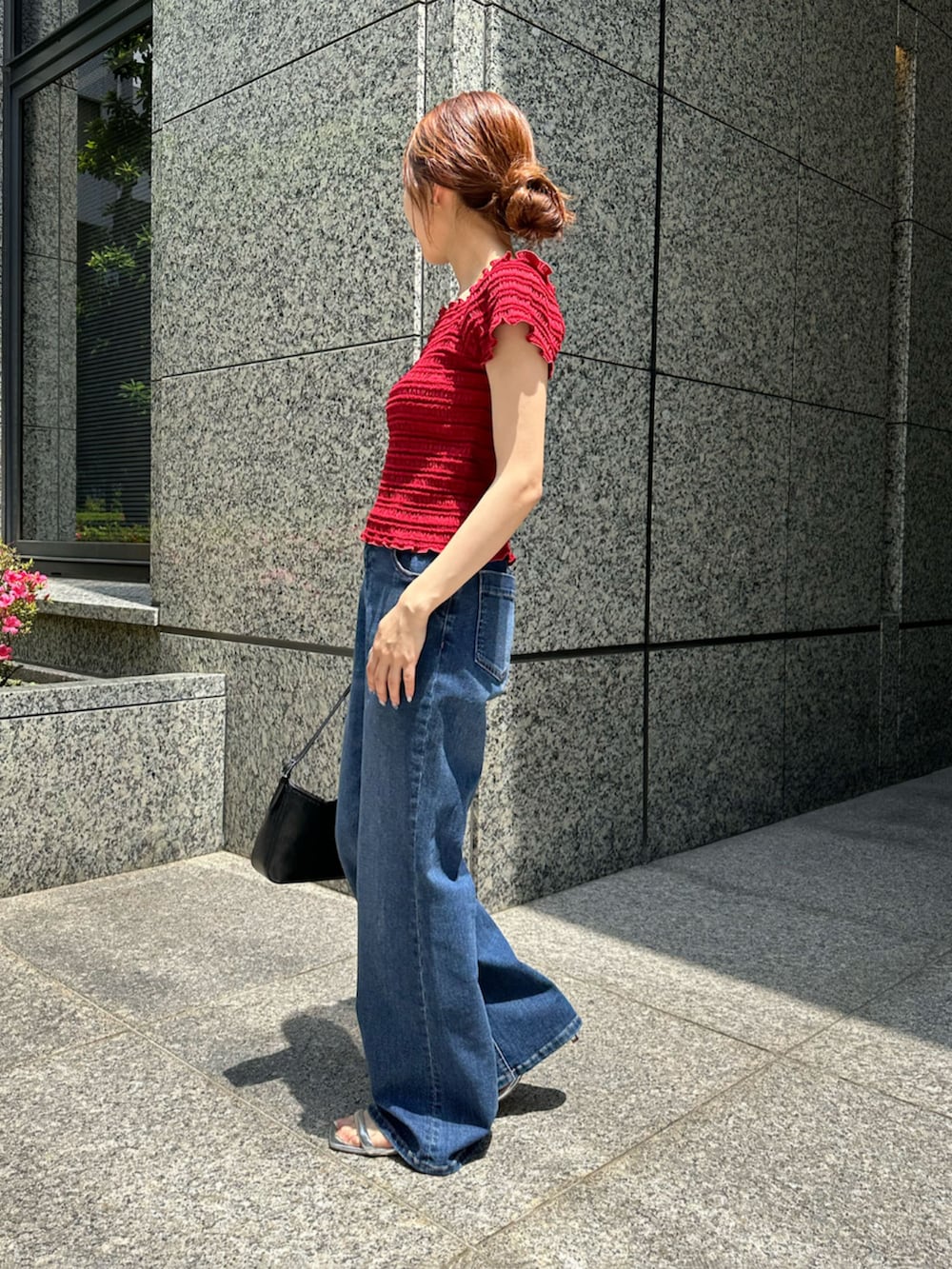 レッド系のTシャツ/カットソー、ブルー系のデニムパンツ、ブラック系のショルダーバッグを着用したレディースの夏コーディネートの3枚目の写真