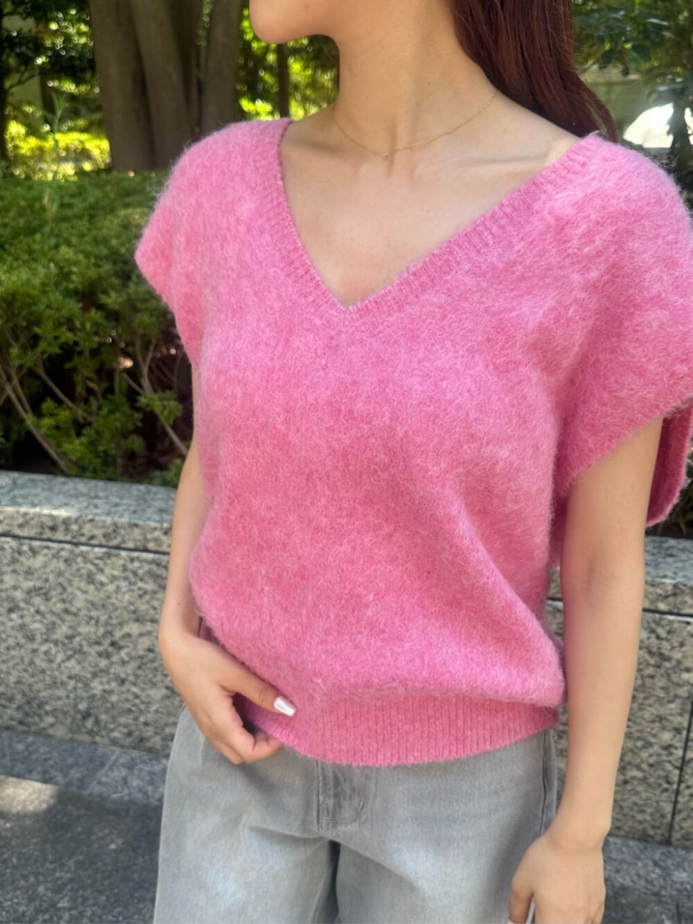 レッド系のベスト、グレー系のデニムパンツ、ブラック系のローファーを着用したレディースの秋コーディネートの3枚目の写真