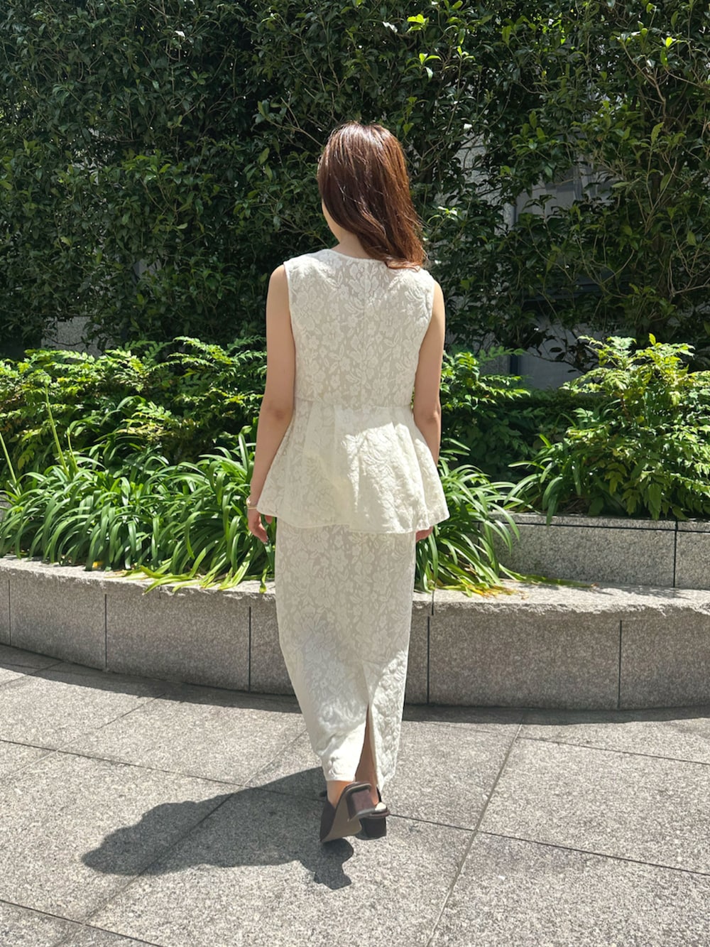 ブラック系のサンダル、ホワイト系のその他アウター、ホワイト系のスカートを着用したレディースの夏コーディネートの2枚目の写真