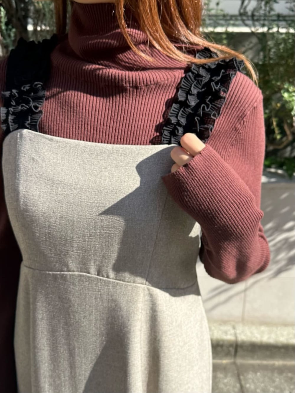 ブラウン系のブーツ、ベージュ系のジャンパースカート、ブラウン系のニット/セーターを着用したレディースの秋コーディネートの4枚目の写真