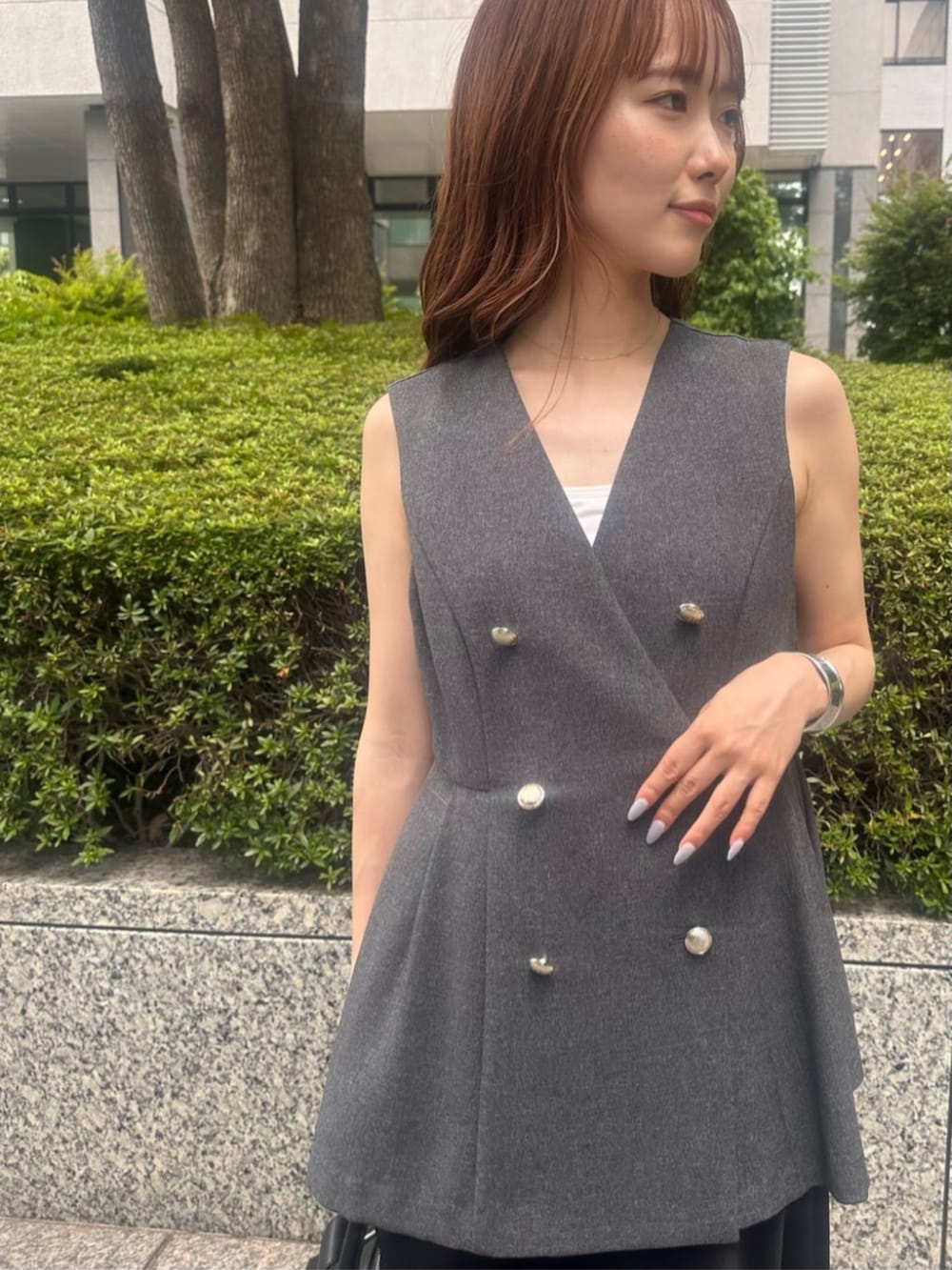 グレー系のその他アウター、ブラック系のスカート、ブラック系のボストンバッグを着用したレディースの秋コーディネートの3枚目の写真