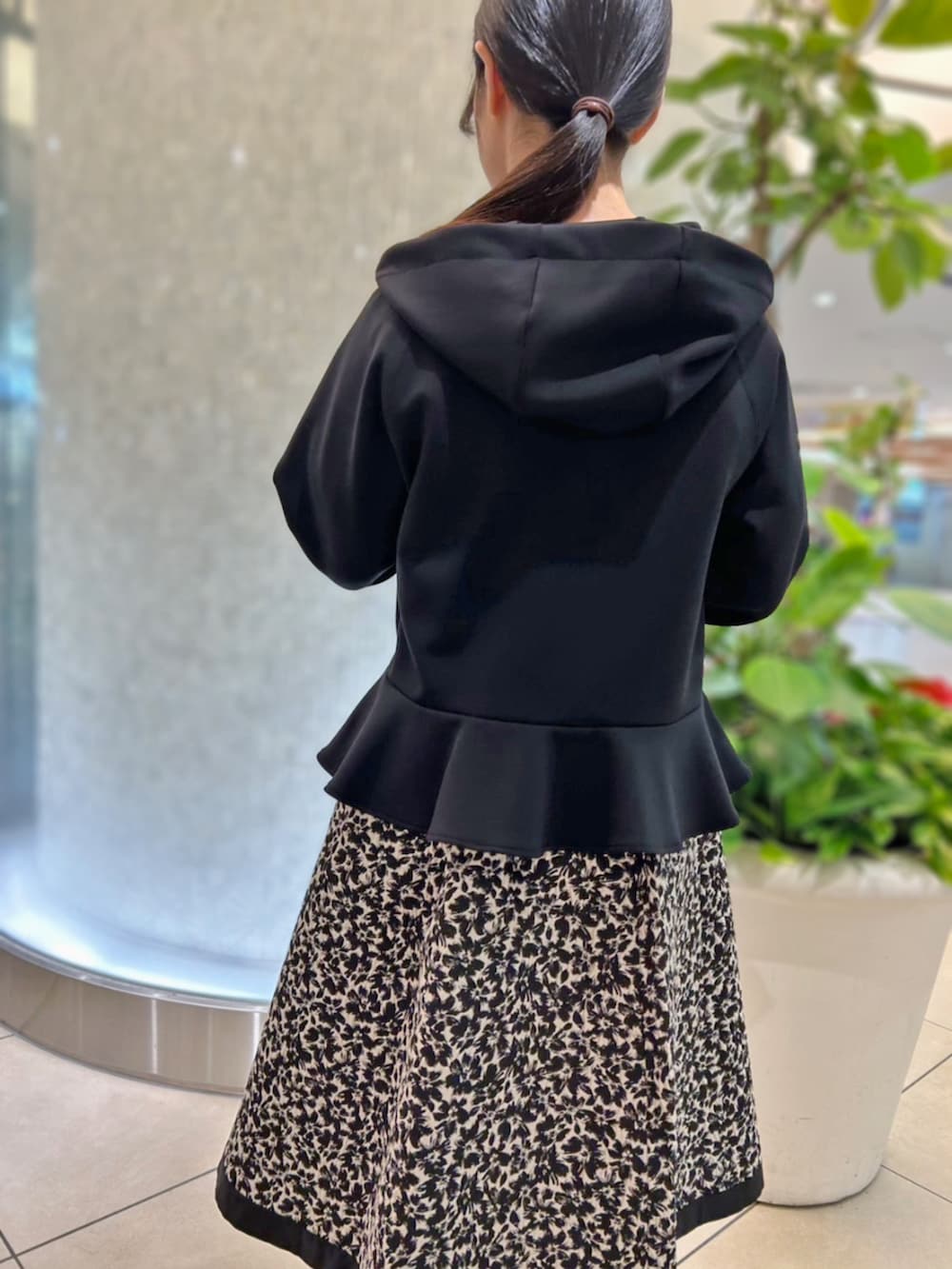 ホワイト系のスカート、ブラック系のパーカーを着用したレディースの秋コーディネートの3枚目の写真